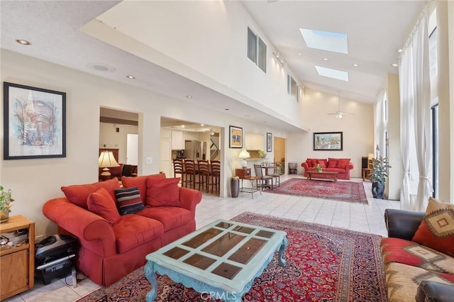 living area featuring recessed lighting, high vaulted ceiling, a skylight, and light tile patterned flooring