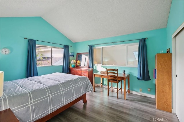 bedroom with baseboards, lofted ceiling, and wood finished floors