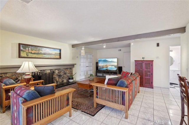 tiled living room featuring a fireplace, beamed ceiling, and track lighting