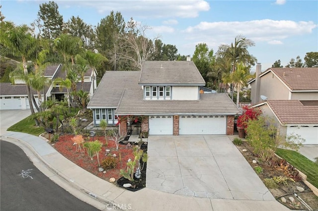 traditional home with a tile roof, concrete driveway, brick siding, and an attached garage