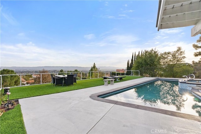 view of swimming pool featuring a pool with connected hot tub, a patio area, a lawn, and fence