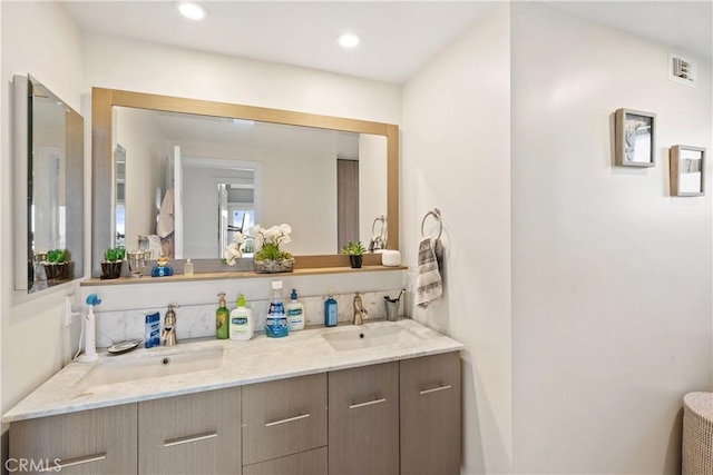 full bath with double vanity, visible vents, a sink, and recessed lighting