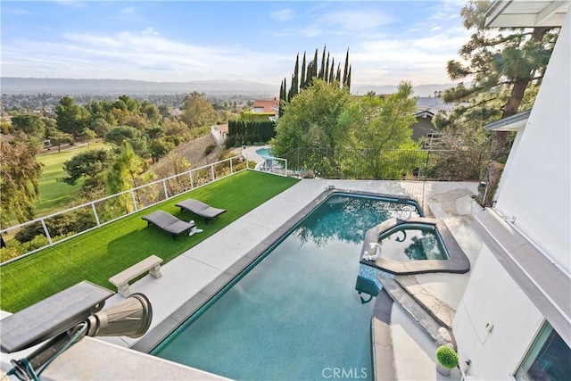 view of pool with a pool with connected hot tub, fence, and a lawn