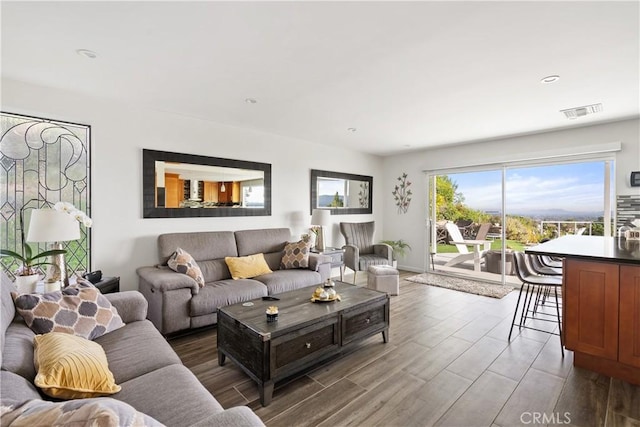 living room featuring wood finished floors, visible vents, and recessed lighting