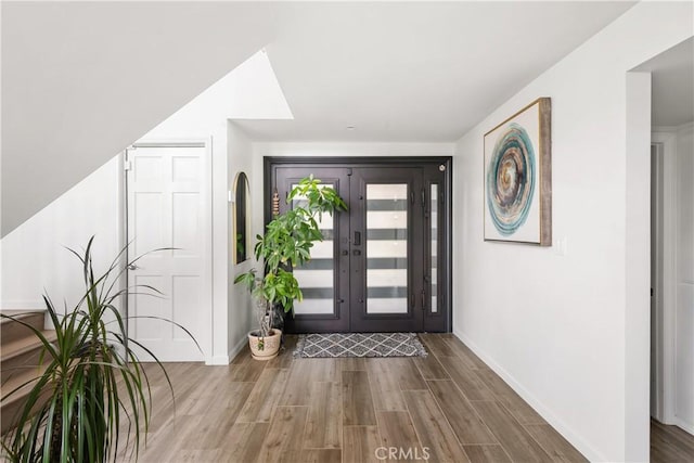 foyer featuring wood finished floors and baseboards