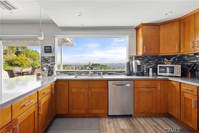 kitchen with a sink, brown cabinetry, and stainless steel dishwasher