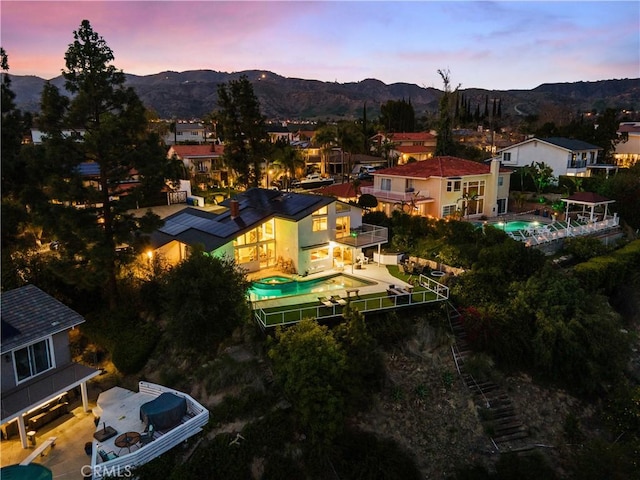 aerial view at dusk featuring a mountain view