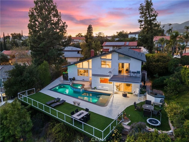 rear view of property featuring a yard, a patio, a fenced backyard, and a balcony