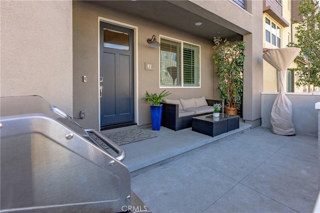 property entrance featuring a patio and outdoor lounge area