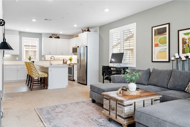 living room with sink and light colored carpet