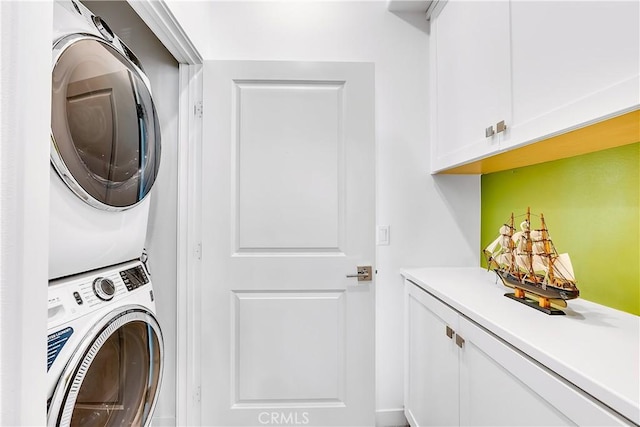 washroom featuring cabinets and stacked washer / drying machine