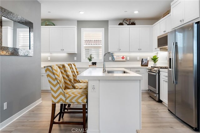 kitchen featuring sink, white cabinetry, plenty of natural light, stainless steel appliances, and a center island with sink