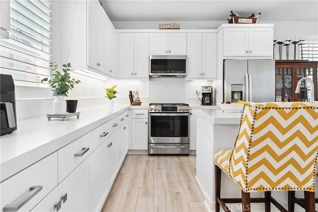 92 Juniper Dr, Rancho Mission Viejo, CA 92694 - kitchen featuring light wood-style flooring, appliances with stainless steel finishes, light countertops, and white cabinetry