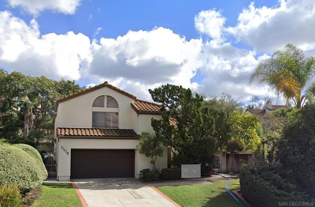 mediterranean / spanish-style home featuring a garage and a front lawn