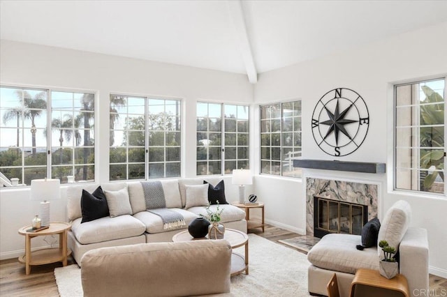 sunroom featuring plenty of natural light, a fireplace, and lofted ceiling with beams