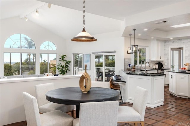 dining area featuring sink and vaulted ceiling