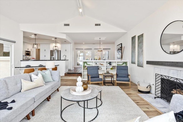 living room featuring lofted ceiling and light hardwood / wood-style flooring