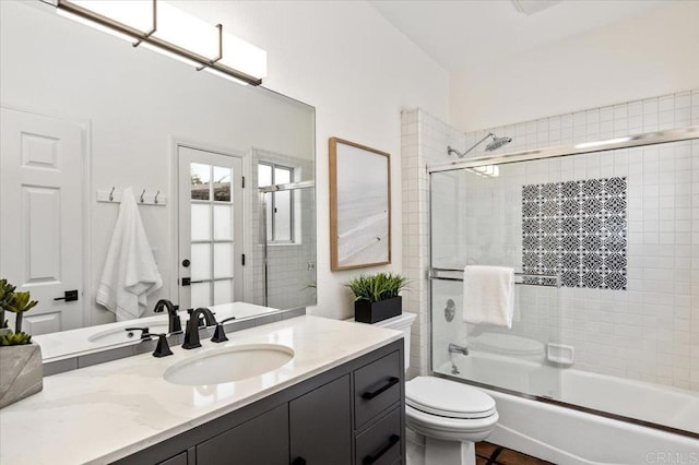 full bathroom featuring enclosed tub / shower combo, vanity, and toilet