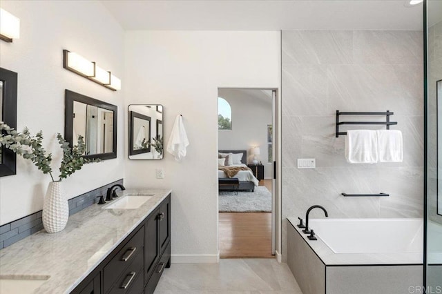 bathroom featuring vanity, tiled bath, and tile patterned floors