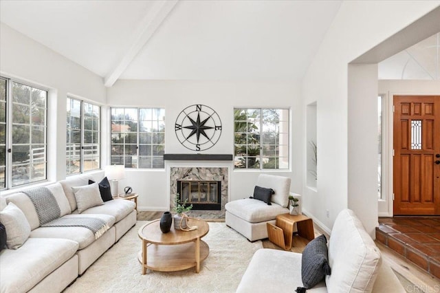 living room featuring a fireplace, high vaulted ceiling, and beamed ceiling