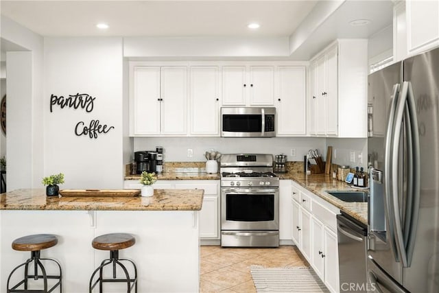 kitchen featuring light stone countertops, white cabinets, and appliances with stainless steel finishes