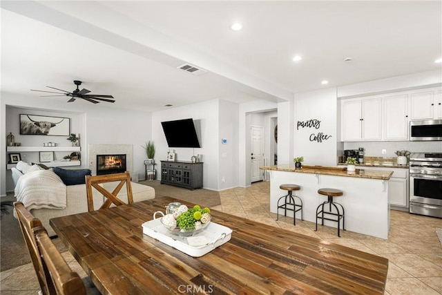 dining space featuring light tile patterned floors and ceiling fan