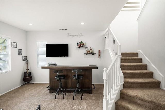 bar with recessed lighting, visible vents, carpet flooring, a bar, and stairs