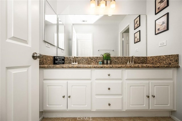 full bathroom featuring double vanity, visible vents, and a sink