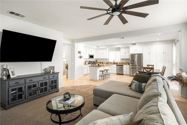 living room featuring ceiling fan and light colored carpet