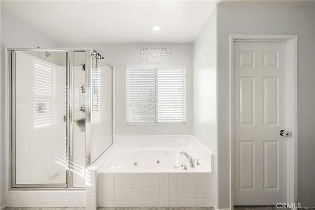 full bath featuring a jetted tub and a shower stall