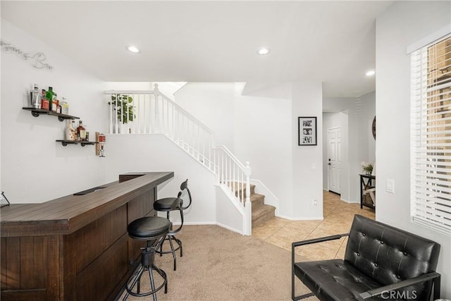 bar featuring a bar, stairway, light colored carpet, and recessed lighting