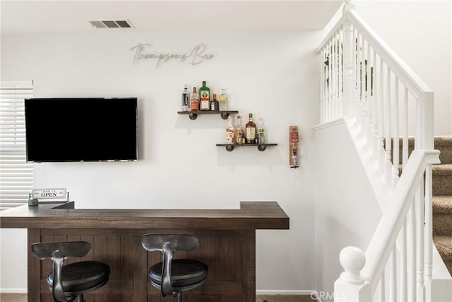 bar featuring a dry bar, stairs, visible vents, and carpet flooring