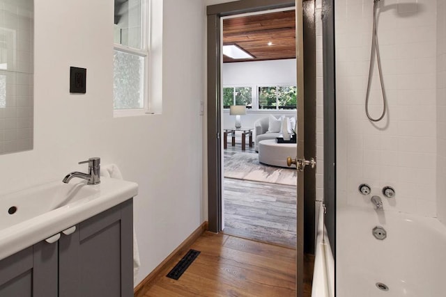 bathroom with hardwood / wood-style flooring, vanity, and bathtub / shower combination