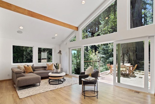 living room featuring beamed ceiling, high vaulted ceiling, and light hardwood / wood-style floors