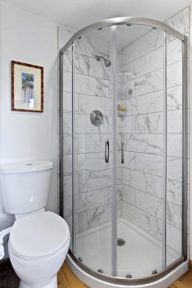 bathroom featuring an enclosed shower, hardwood / wood-style floors, and toilet