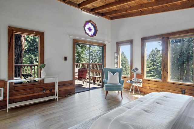 living area with beam ceiling, wood-type flooring, and wood ceiling