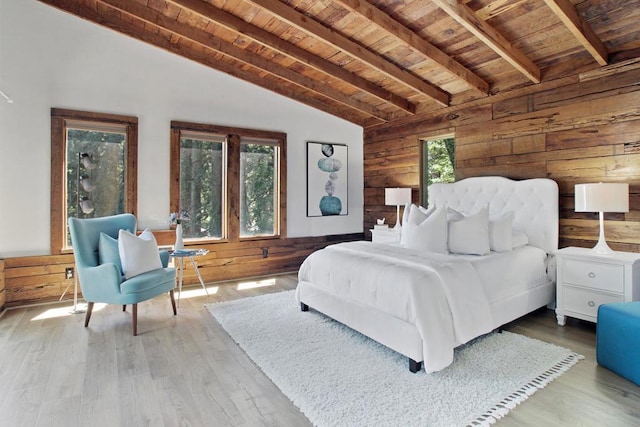 bedroom with multiple windows, vaulted ceiling with beams, wood ceiling, and wooden walls