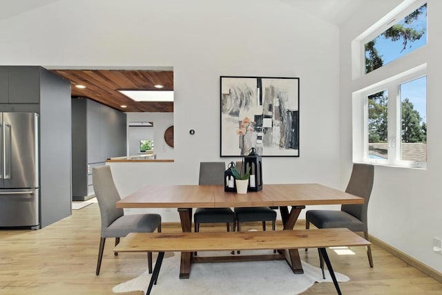 dining space featuring high vaulted ceiling and light wood-type flooring