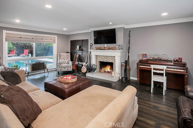 living room featuring a tile fireplace, crown molding, and dark hardwood / wood-style floors