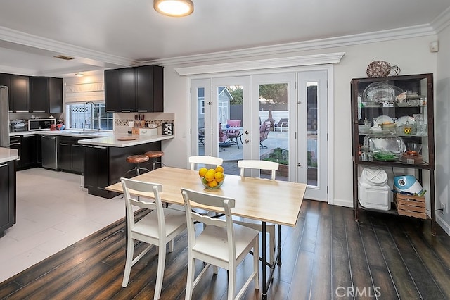 dining space featuring hardwood / wood-style flooring, crown molding, and a healthy amount of sunlight