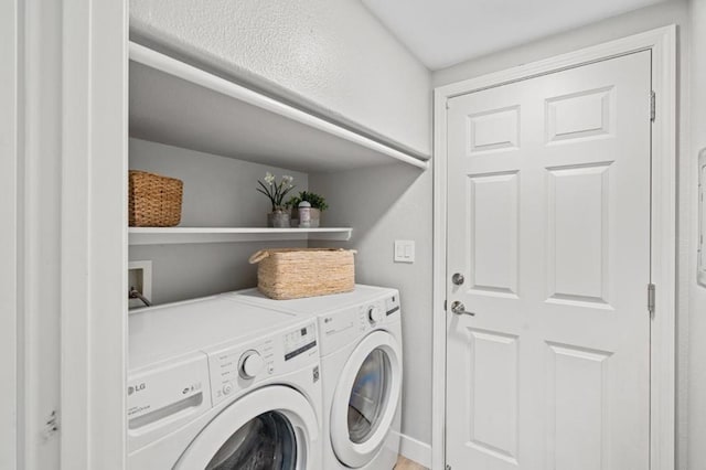 clothes washing area with washing machine and dryer