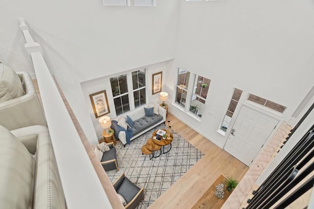 living room with hardwood / wood-style flooring and a towering ceiling