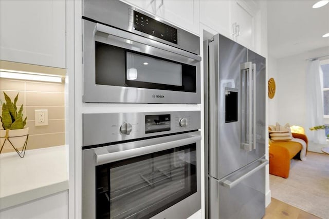 kitchen featuring white cabinetry and high quality fridge