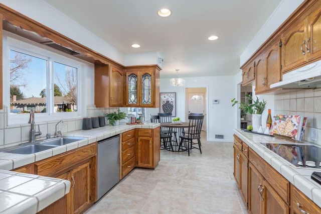 kitchen with dishwasher, pendant lighting, sink, and tile countertops