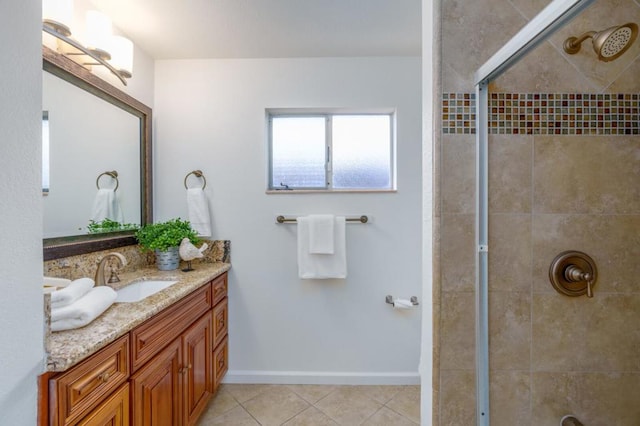 bathroom with vanity, tile patterned flooring, and a tile shower