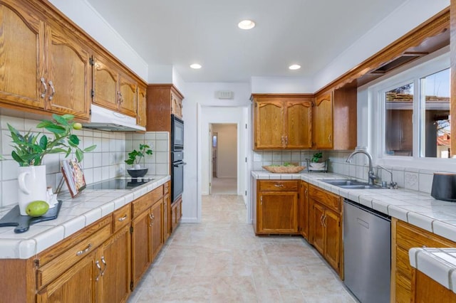 kitchen featuring tile counters, sink, decorative backsplash, and black appliances