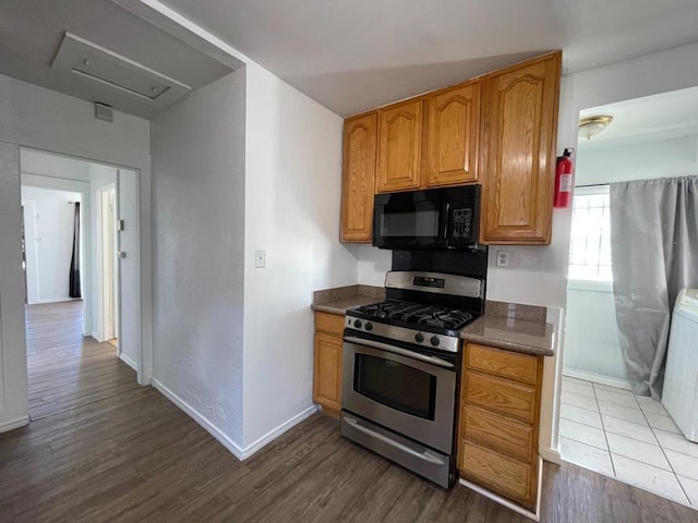 kitchen with dark hardwood / wood-style floors and stainless steel range with gas stovetop