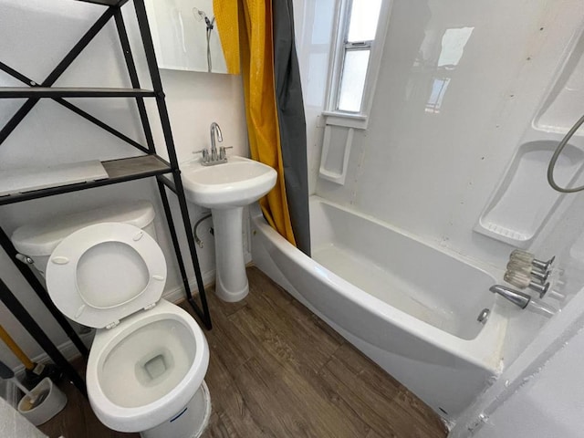 full bathroom with hardwood / wood-style floors, shower / bath combo, sink, and toilet