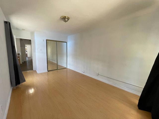 unfurnished bedroom with light hardwood / wood-style flooring and a closet