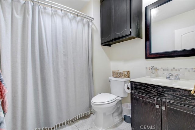 bathroom with tasteful backsplash, vanity, toilet, and tile patterned flooring